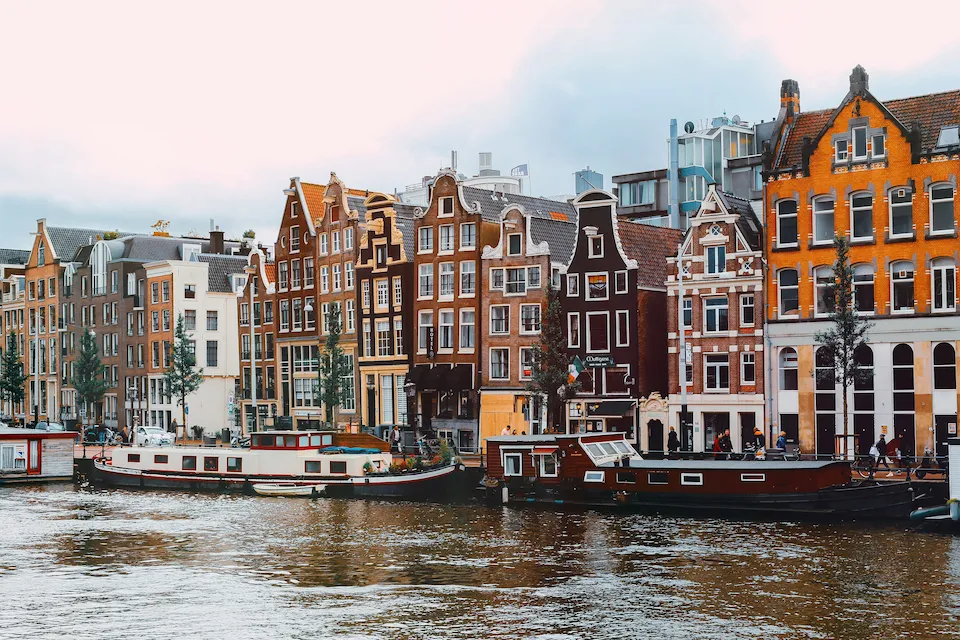Amsterdam canal at sunset with boats and reflections